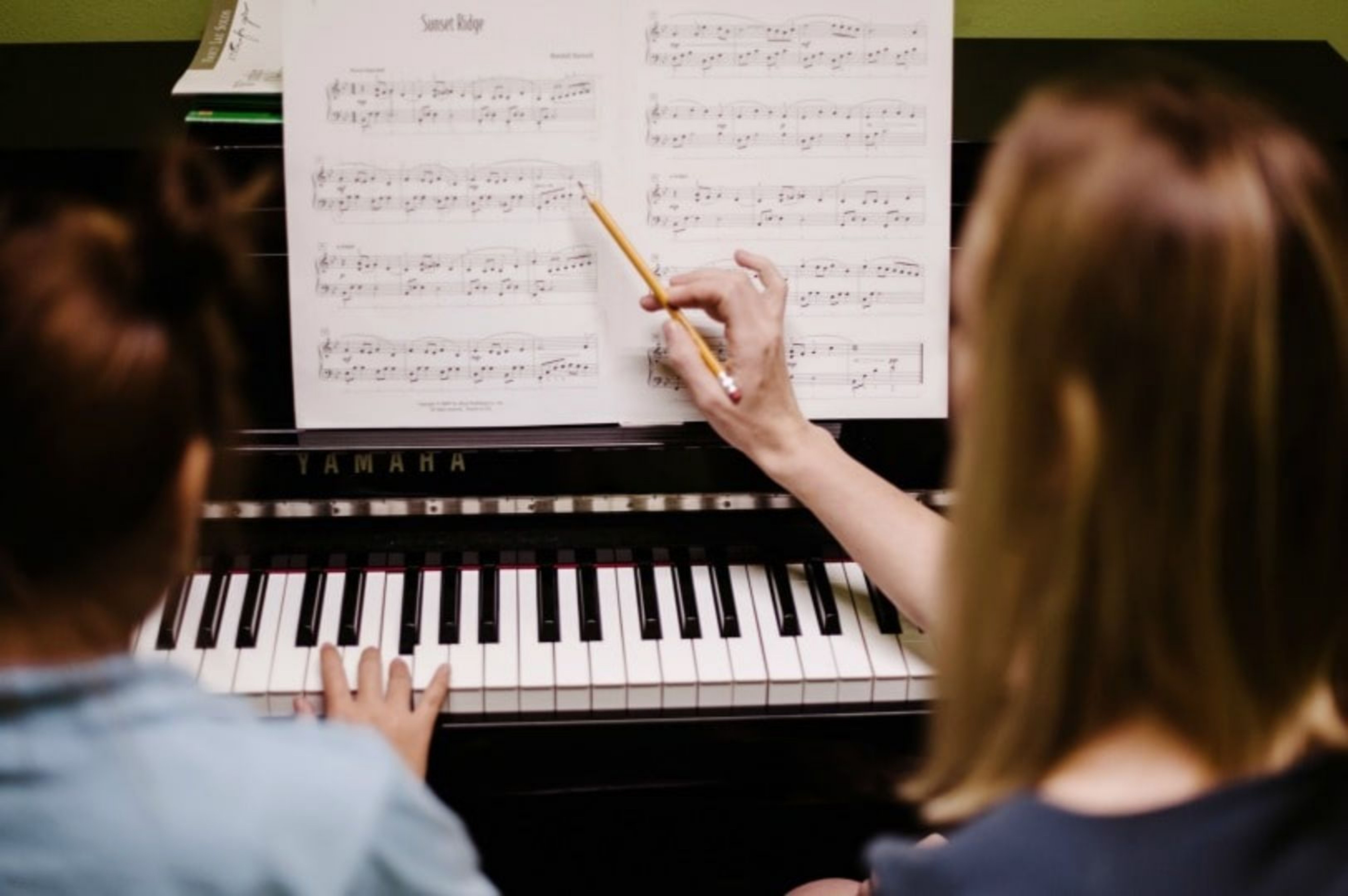 piano teacher instructing a student